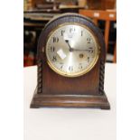 A 1920s/30s oak veneered mantle clock, six inch silvered dial, the case with barley twist columns