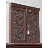 A Victorian oak corner cupboard of small proportions, the double doom carved in high relief with
