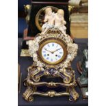 A Meissen mantle clock on stand, of Rococo form, the blue ground heavily gilded and encrusted with