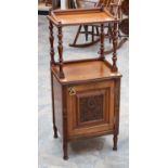 A Victorian mahogany bedside cabinet fitted with a single door, with a carved panel