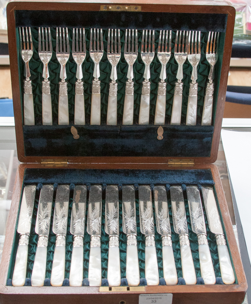 A boxed twelve setting dessert set, mother of pearl handles and engraved detail to blade (mahogany)