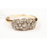 An Edwardian diamond cluster ring, having three central old cut stones,