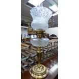 A late 19th century brass oil lamp with a cut glass reservoir,