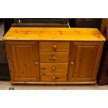 A contemporary solid pine sideboard, fitted with two doors and four drawers