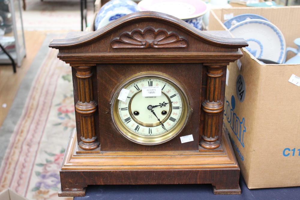 An oak cased mantle clock with German movement, half striking the five inch enamelled dial within a