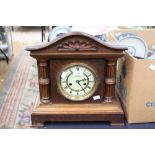 An oak cased mantle clock with German movement, half striking the five inch enamelled dial within a