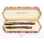 A boxed Conway Stewart fountain pen (12) red and gold marble casing and a matching propelling