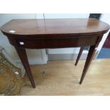 A George III mahogany fold over card table, the top inlaid and cross banded in rosewood,