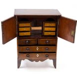 An early 19th Century collectors cabinet in the Georgian style raised on legs,