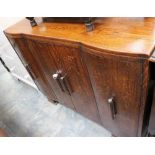 An Art Deco oak sideboard fitted with four doors, each end of bow front.