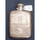 An early 20th Century silver hip flask and hinged cover, monogrammed with silver sleeve,