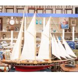 A model four casting sailing vessel, wooden deck and red hull,