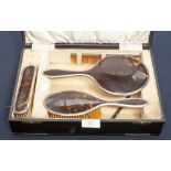 A cased silver/tortoiseshell brush set