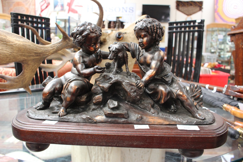 A bronzed figure group of two children with a dog,