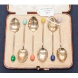 A set of George V silver and coloured enamelled coffee spoons,