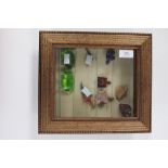 A small glass shelved wall hanging display case with two glass pigs and eight polished hardstone