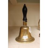 A brass school bell with turned wooden handle