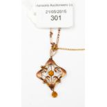 An Edwardian rose gold (9ct) pendant with amber coloured stones, all in 4.