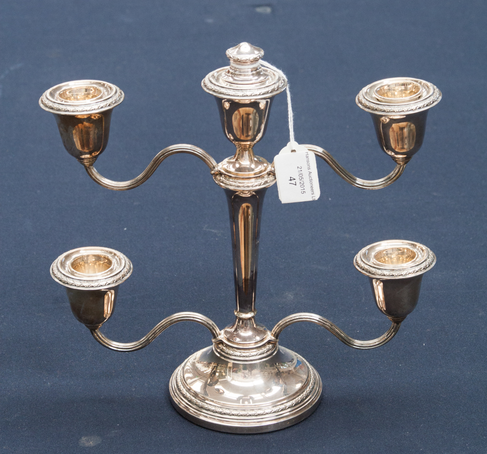 A silver candelabrum, having four branches, a centre candle holder and finial,