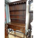 A George III style oak dresser with rack, the rack with three shelves,