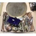 A box of assorted brassware including a pair of candlesticks, brass fireside figures,
