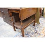 An early 20th Century oak two tier Pembroke table, raised on turned legs.