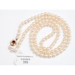 A single-row strand of cultured pearls, 9ct gold clasp set with a garnet and pearls,