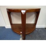 An Art Deco style hardwood console table, demi-lune form on three legs,