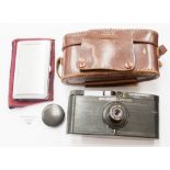A Vulcanite Purma special (English) camera in stitched leather case and a chrome cigarette and