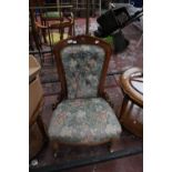A mid Victorian mahogany ladies chair with button back and upholstered seat and raised on turned
