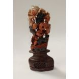 A soapstone carved floral ornament, depicting fish amongst foliage, raised on a pierced stand,