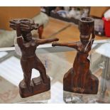 A pair of folk art carved wooden candlesticks modelled as native indigenous figures carrying