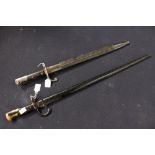 A 19th century bayonet and scabbard, possibly French, the scabbard with a leather coating,