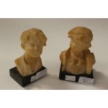 Two carved alabaster busts of boys, on marble bases, one signed Picciole,