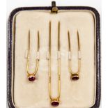A set of Asprey London gold and ruby cravat pins in fitted box