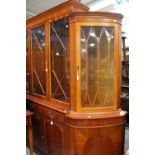 A contemporary yew veneered four door glazed bookcase,