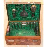 An Edwardian travel toilet case with silver topped glass bottles, mirror, brushes, clock case,