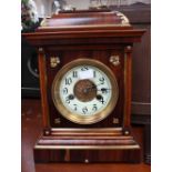 A late 19th Century German rosewood cased eight day mantle clock, with a white enamelled dial,