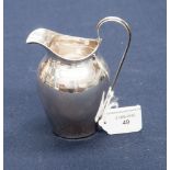 A George V silver cream jug of baluster form,