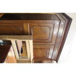 An early 20th Century mahogany double wardrobe fitted with two - panel doors,