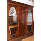 An Edwardian mahogany four piece bedroom suite, comprising two door wardrobe with central mirror,