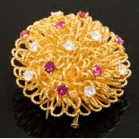 A diamond and ruby brooch set atop a looped raised circular brooch, continental unmarked,