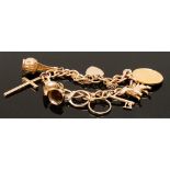 A 9 ct gold Padlock Charm Bracelet suspending seven various gold charms and an Edward VII gold