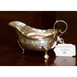 A George III sterling silver wavy rim sauce boat on three pad feet with S scroll handle,