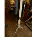 A wooden and painted floor lamp, having