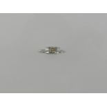 An 18 carat white gold three stone diamond ring, set central champagne coloured stone of approx. 0.2