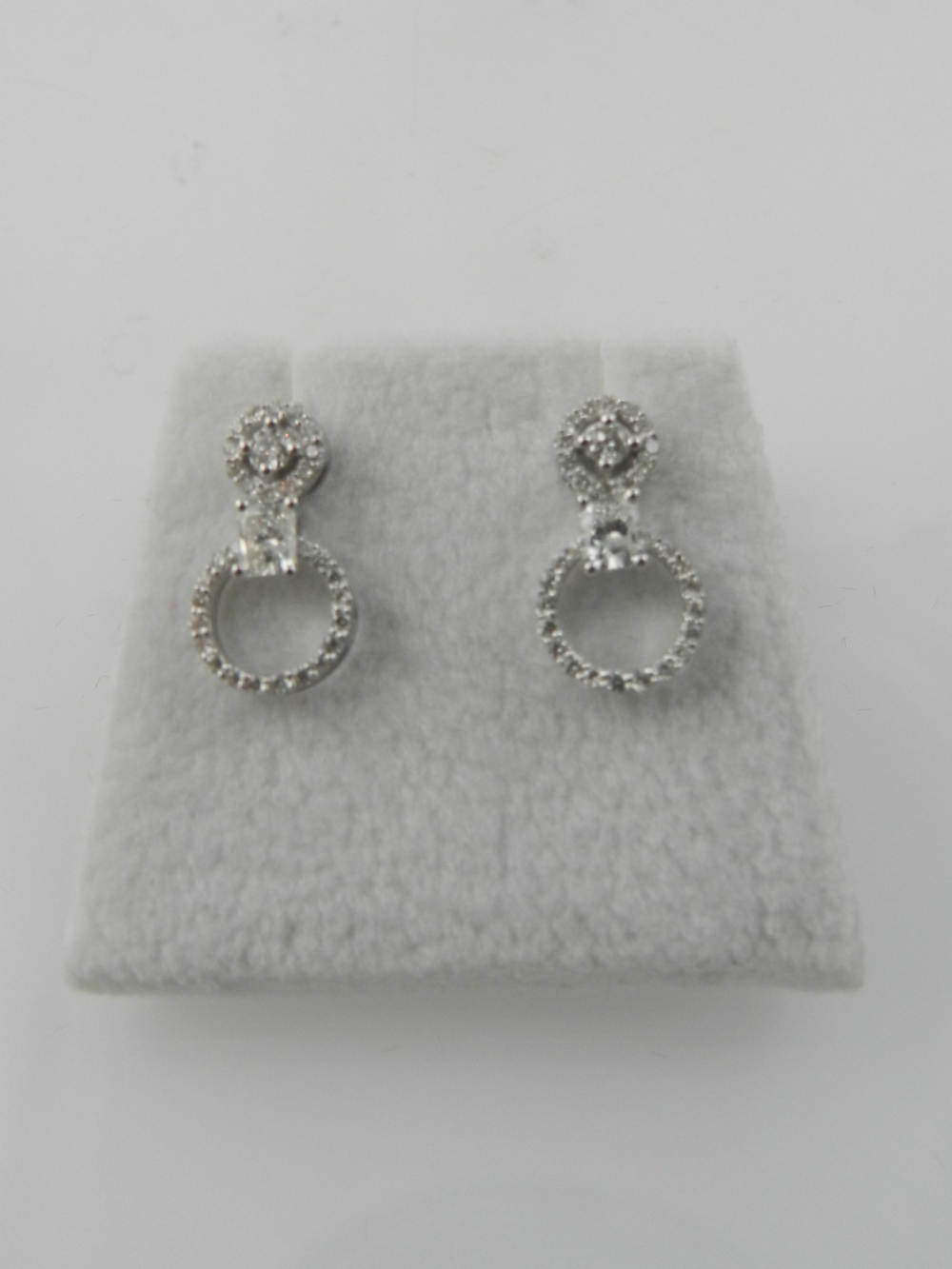 A pair of 18 carat white gold screwback earrings, set round cut cluster diamonds, above princess cut