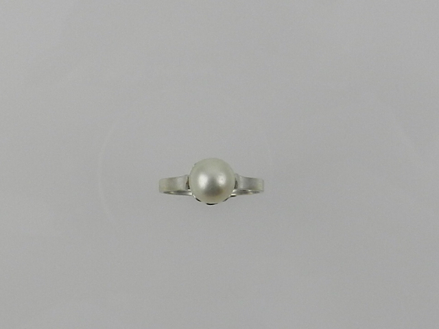 A white metal and pearl ring.