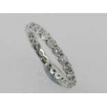 A white metal and diamond eternity ring, set with twenty five small diamonds.