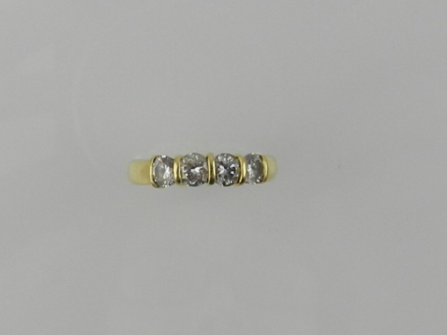 A yellow metal and diamond ring, set four diamonds of approx. 0.7 carats combined, the shank stamped